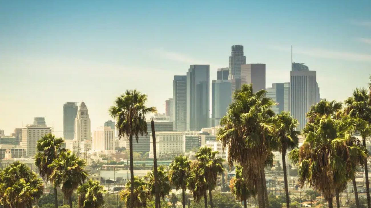 the Los Angeles city skyline with a bright blue sky