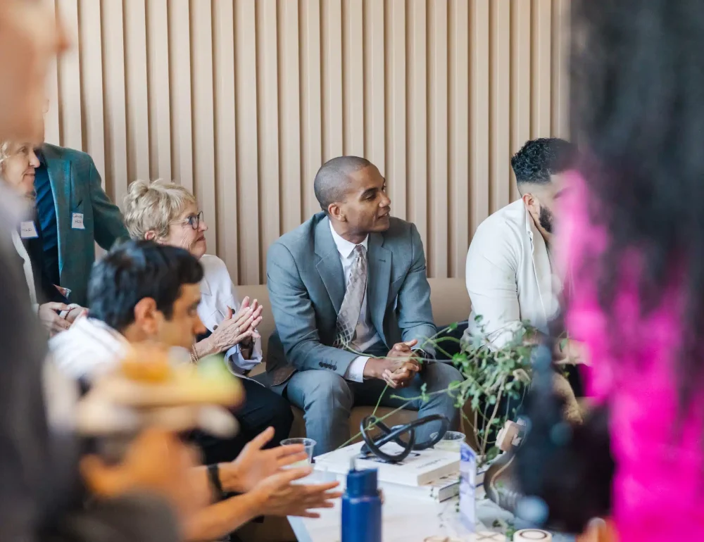 a group of people dressed formally sitting down and listening